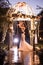 Side view of elegant couple embracing in illuminated gazebo at night