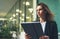 Side view of an elegant girl in a business black suit holding a tablet and reading correspondence, financial adviser uses Internet