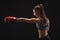 Side view of emotional young woman with boxing gloves