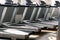 Side view of empty treadmills on wooden floor near panoramic window in fitness club