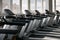 Side view of empty treadmills on wooden floor near panoramic window in fitness club. Side view