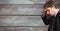 Side view of exhausted businessman touching forehead against wooden wall