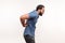 Side view exhausted unhealthy bearded man touching aching back, suffering lower lumbar discomfort, muscle pain, injured spine disk