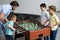 side view of father and little sons playing table football together