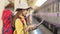 Side view of female backpacker checking her plan on digital tablet at train station