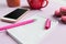 The side view on female desk. The phone and french macarons on trendy pink desk.