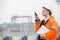 Side view of female engineer using walkie-talkie in shipping yard