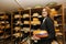 Side view of female salesperson holding cheese in store