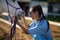 Side view of female vet checking horse teeth