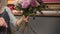 Side view of a flower shop assistant tying a bunch of flowers holding them in hands with the ribbon. Slowmotion shot