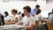 Side view on focused teenager male student sitting at library desk, preparing for exam