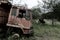 Side view of front part from a broken old truck that has been badly damaged abandoned in the middle of a park with scary vibes