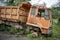 Side view of front part from a brown broken brown old truck that has been badly damaged abandoned in the middle of a park