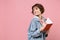 Side view of funny woman student in denim clothes backpack isolated on pink background. Education in high school