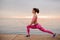 Side view girl doing stretch exercises on the sunrise on the seaside