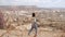 Side view of girl walking and looking at scenic valley on horizon