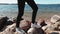 Side view of a girl walking on stones on the beach of the Minsk Sea