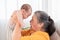 Side view grandmother and newborn baby play together at home, Grandma holding adorable infant in air and looking with love and