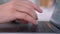 Side view of hands pressing keys of black laptop keypad. Action. Close up of a keyboard and man hands typing on modern