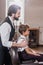 side view of handsome barber looking at reflection of little kid sitting in chair