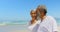 Side view of happy active senior African American couple walking on beach in the sunshine 4k