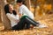 Side view of happy Asian sister and brother playing and reading book at the park in the natural sunlight, concept leisure hobby