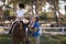 Side view of happy female jockey teaching girl