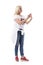 Side view of happy modern middle age woman in fifties wearing jeans and t-shirt using smart phone