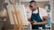Side view happy smiling cheerful creative talented inspired old African American senior man artist male painter in apron