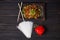 Side view of Harusame Rice noodles with meat served in wooden plate on dark background.