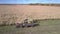 Side view harvester with tractor and lorry gather corn mass
