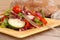 Side view of a healthy salad on a yellow plate with rustic bread