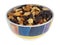 Side view of high energy trail mix with roasted nuts and fruit in a colorful bowl isolated on a white background
