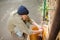 Side view of homeless man washing hands in old sink in the street.