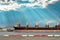 Side view of a huge bulk cargo ship docking at harbor discharging steel cargo with a beautiful sky background.