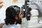 Side view of Indian man is checking the eye vision with phoropter eyesight measurement testing machine