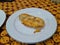 Side view of indonesian traditional sweet oily snack fried fries banana on white plate on the table of restaurant