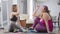 Side view of joyful slim and overweight women giving high-five sitting on exercise mat talking smiling. Positive