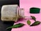 Side view of Kabasura powder in glass jar with neem leave