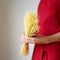 Side view of a lady in red apron holding some spaghetti. Conceptual image shot