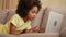 Side view little African American girl looks at information on laptop or communicates in online chat, social networks