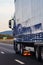 Side view of loaded European truck in motion on asphalt road, transportation and delivery concept. Detail on delivery truck.