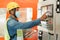 Side view of man engineer  working on machine control panel display and holding tablet digital in the factory