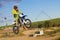 Side view of man performing stunt with motorcycle on motocross track