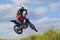 Side view of man performing stunt with motorcycle on motocross track