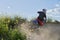 Side view of man performing stunt with motorcycle on motocross track