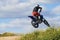 Side view of man performing stunt with motorcycle on motocross track