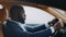 Side view man sitting behind steering wheel at car. African man dancing at car