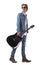 Side view of masculine guitarist carrying guitar walking and looking back over shoulder.