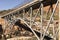 Side View Metal Construction Of Bridge Supports, Infrastructure. Blue Sky And Mountain